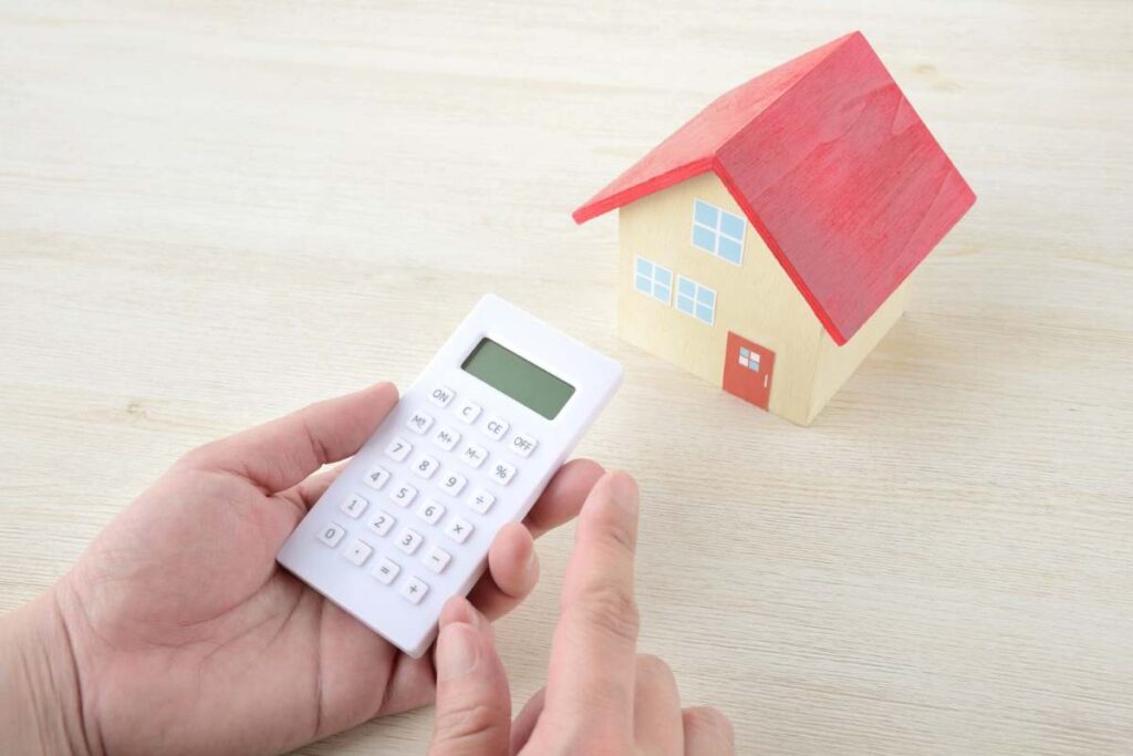 quand faire estimer son bien immobilier image avec une maison et une main tenant une calculatrice illustrant l'estimation immobilière